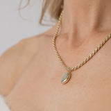 model wearing gold oval locket with rope chain necklace