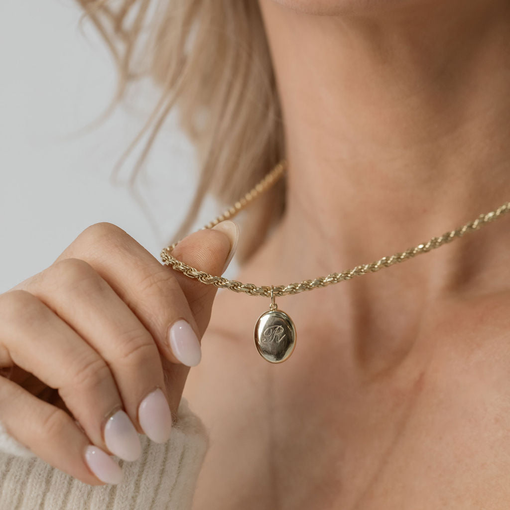 gold oval locket engraved with gold rope chain necklace