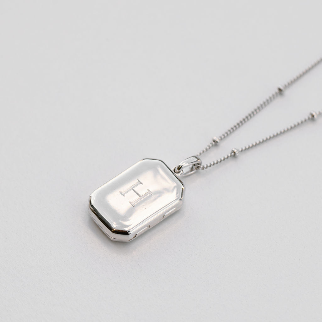 silver rectangular bevel locket engraved with a bead chain necklace