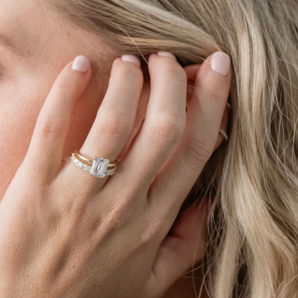 emerald cut solitaire engagement ring with statement diamond wedding ring
