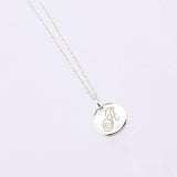white gold disc pendant with engraved letter